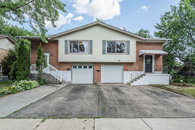 1549 Revere Cir, Schaumburg, IL 60193 - split level home featuring asphalt driveway, a garage, and brick siding