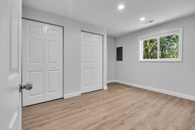 1549 Revere Cir, Schaumburg, IL 60193 - unfurnished bedroom with electric panel, two closets, light wood-style floors, and recessed lighting