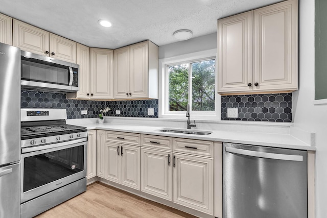 1549 Revere Cir, Schaumburg, IL 60193 - kitchen featuring appliances with stainless steel finishes, cream cabinets, light countertops, decorative backsplash, and a textured ceiling