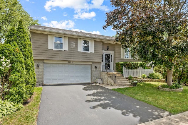 215 S Park Blvd, Streamwood, IL 60107 - split foyer home with brick siding, driveway, an attached garage, and a front lawn