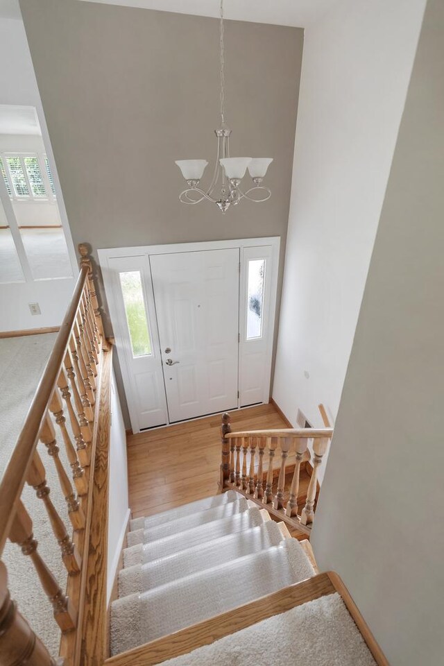 215 S Park Blvd, Streamwood, IL 60107 - entrance foyer featuring a towering ceiling, wood finished floors, a chandelier, and stairs