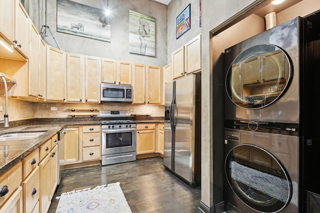 1215 W Gunnison St Unit 202, Chicago, IL 60640 - kitchen with stainless steel appliances, stacked washer / drying machine, light brown cabinets, and dark wood-style floors