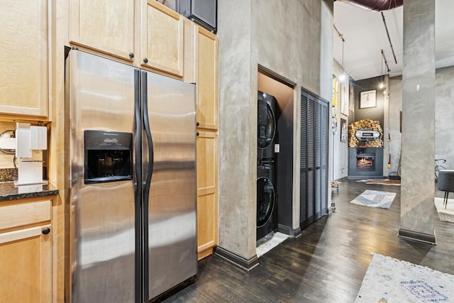 1215 W Gunnison St Unit 202, Chicago, IL 60640 - kitchen featuring stainless steel fridge with ice dispenser, stacked washer and clothes dryer, dark wood-style floors, light brown cabinets, and a high ceiling