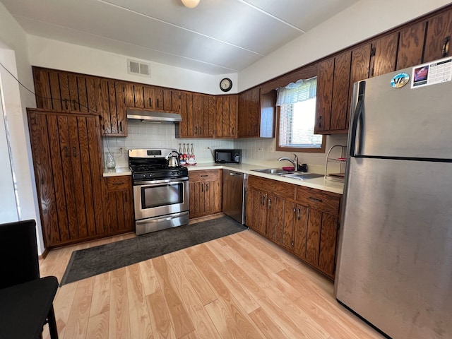 11111 Heritage Dr Unit 2A, Palos Hills, IL 60465 - kitchen with appliances with stainless steel finishes, light countertops, under cabinet range hood, and decorative backsplash