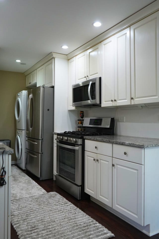 8234 Portsmouth Dr Unit D, Darien, IL 60561 - kitchen with stainless steel appliances, estacked washer and dryer, white cabinetry, recessed lighting, and dark wood-type flooring
