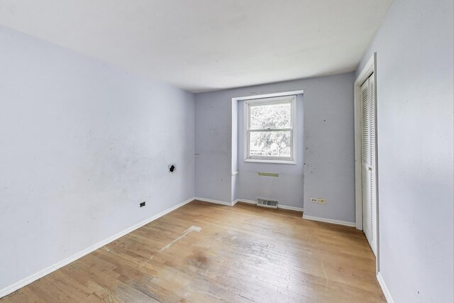 418 Surrey Ln, Lindenhurst, IL 60046 - unfurnished bedroom featuring light wood-style flooring and a closet