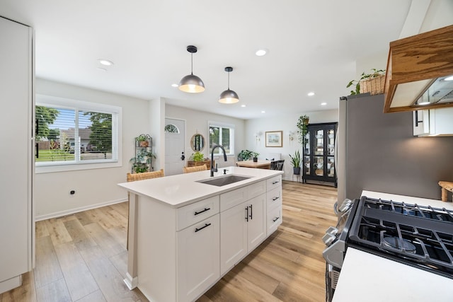750 Shady Ln, Aurora, IL 60506 - kitchen with stainless steel appliances, light wood finished floors, white cabinets, light countertops, and hanging light fixtures