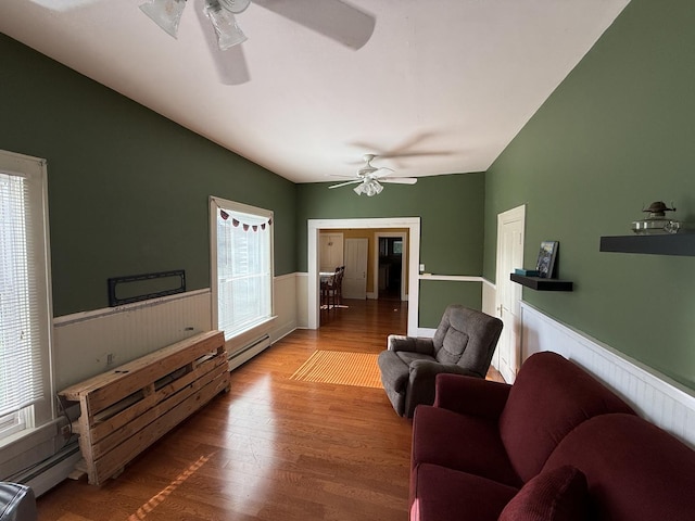 325 E Waupansie St, Dwight, IL 60420 - living area with ceiling fan, a wainscoted wall, baseboard heating, plenty of natural light, and vaulted ceiling