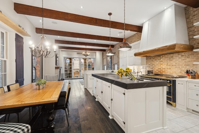 1414 N Mohawk St, Chicago, IL 60610 - kitchen with stainless steel range with gas stovetop, custom range hood, a chandelier, a center island with sink, and tasteful backsplash