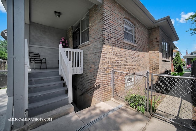 11402 S Calumet Ave, Chicago, IL 60628 - doorway to property with brick siding, a gate, and covered porch