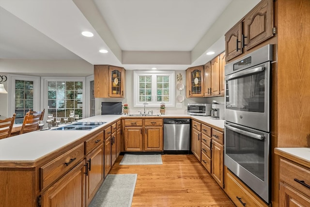 124 Hidden Oaks Dr, Barrington, IL 60010 - kitchen featuring stainless steel appliances, plenty of natural light, brown cabinetry, glass insert cabinets, and recessed lighting
