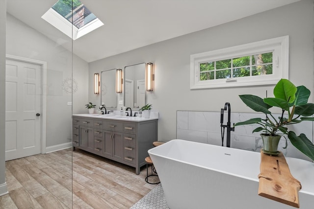 124 Hidden Oaks Dr, Barrington, IL 60010 - full bathroom with a skylight, double vanity, a freestanding tub, lofted ceiling, and wood finished floors