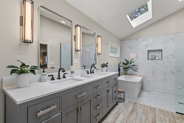 124 Hidden Oaks Dr, Barrington, IL 60010 - bathroom with a skylight, double vanity, a freestanding bath, wood finished floors, and vaulted ceiling