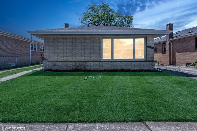 12830 S Carpenter St, Calumet Park, IL 60827 - rear view of house featuring a lawn, brick siding, and a chimney
