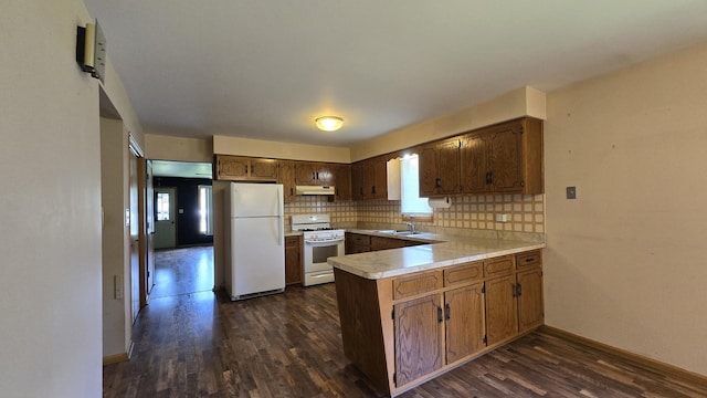 7121 Oak Grove Ave, Justice, IL 60458 - kitchen featuring white appliances, a peninsula, under cabinet range hood, light countertops, and dark wood finished floors