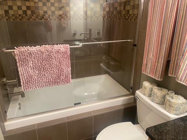 212 N Center St Unit 205, Bloomington, IL 61701 - bathroom featuring tiled shower and toilet
