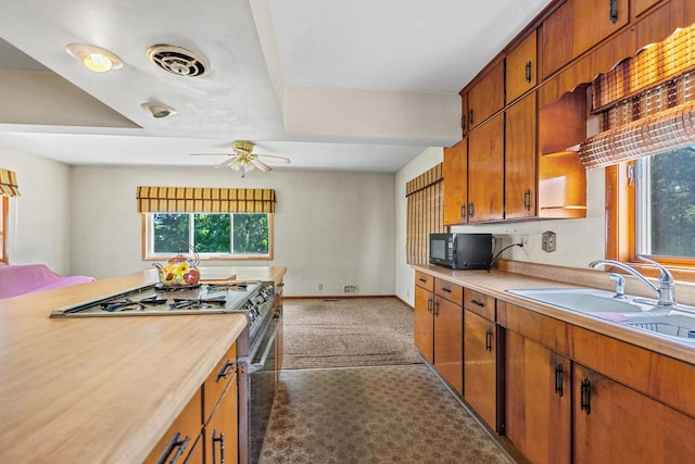 1716 Court St, Mchenry, IL 60050 - kitchen with range with gas stovetop, black microwave, light countertops, and brown cabinetry