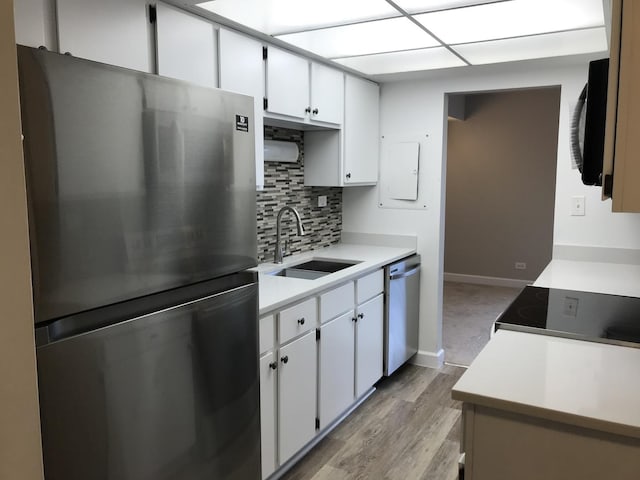 6340 Americana Dr Unit 705, Willowbrook, IL 60527 - kitchen with appliances with stainless steel finishes, backsplash, light countertops, light wood-style floors, and white cabinetry