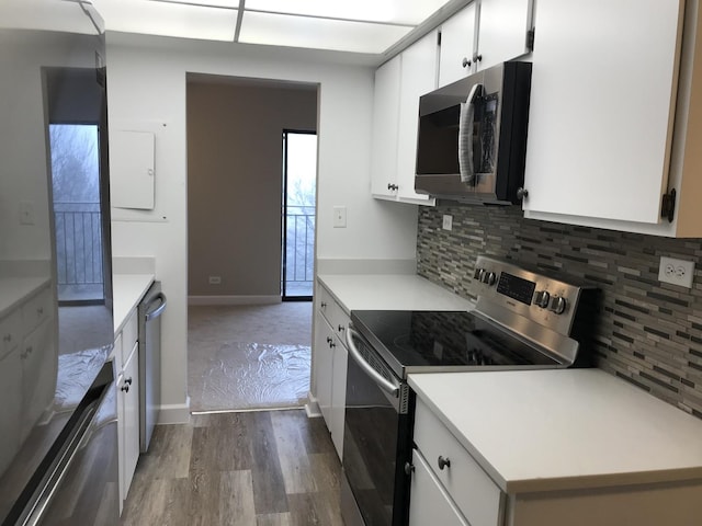 6340 Americana Dr Unit 705, Willowbrook, IL 60527 - kitchen with appliances with stainless steel finishes, light countertops, dark wood-style floors, tasteful backsplash, and white cabinets