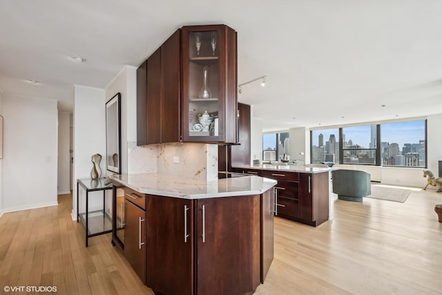 1560 N Sandburg Ter Unit 4301-4303, Chicago, IL 60610 - kitchen with a peninsula, light wood-style flooring, backsplash, open floor plan, and glass insert cabinets