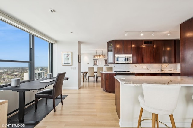 1560 N Sandburg Ter Unit 4301-4303, Chicago, IL 60610 - kitchen with stainless steel microwave, light wood-style flooring, black electric range oven, tasteful backsplash, and rail lighting