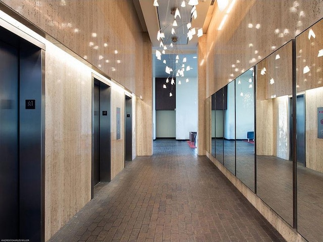 1560 N Sandburg Ter Unit 4301-4303, Chicago, IL 60610 - corridor with elevator, a high ceiling, brick patterned flooring, and a chandelier