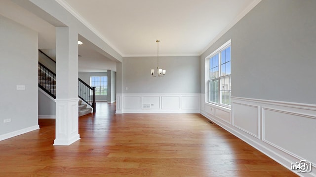 24433 W Bantry Ln, Shorewood, IL 60404 - unfurnished dining area featuring a chandelier, light wood-style flooring, crown molding, stairway, and wainscoting