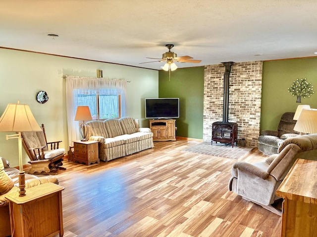 1217 Retz Dr, Ottawa, IL 61350 - living room featuring a wood stove, ceiling fan, and light wood-type flooring