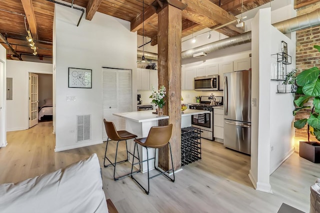 1740 N Maplewood Ave Unit 301, Chicago, IL 60647 - kitchen featuring stainless steel appliances, a wood ceiling with exposed beams, light wood-style flooring, light countertops, and rail lighting