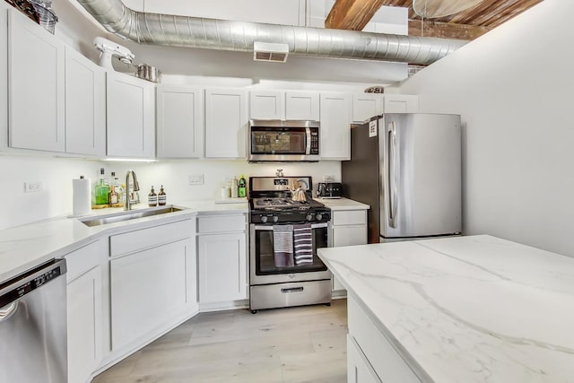 1740 N Maplewood Ave Unit 301, Chicago, IL 60647 - kitchen with stainless steel appliances, white cabinets, light stone counters, and light floors