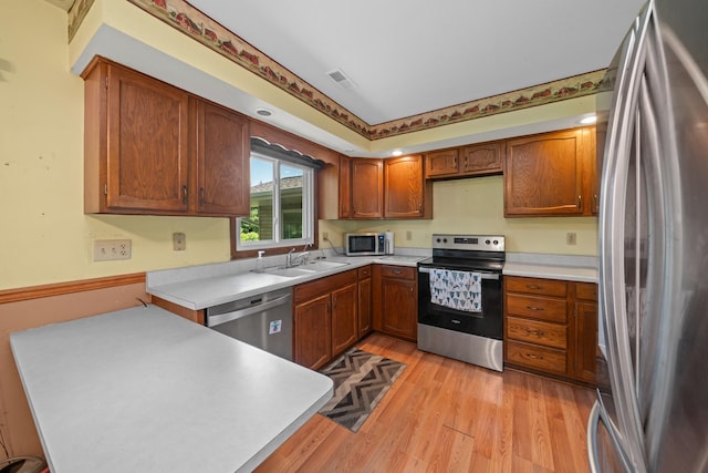 2689 Lynnville Ct, Lindenwood, IL 61049 - kitchen featuring appliances with stainless steel finishes, light wood-type flooring, light countertops, and brown cabinetry
