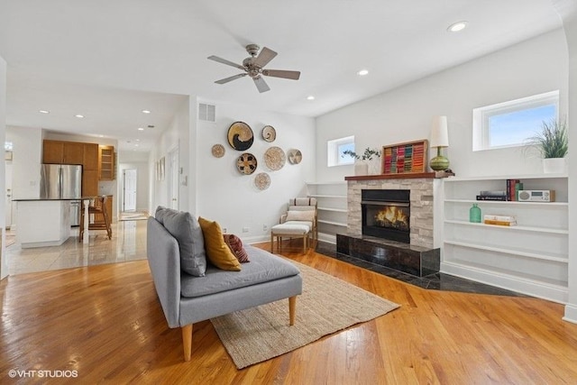 4637 N Drake Ave Unit 3, Chicago, IL 60625 - living room with a tiled fireplace, wood finished floors, a ceiling fan, and recessed lighting