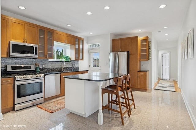 4637 N Drake Ave Unit 3, Chicago, IL 60625 - kitchen featuring appliances with stainless steel finishes, recessed lighting, brown cabinets, backsplash, and a center island