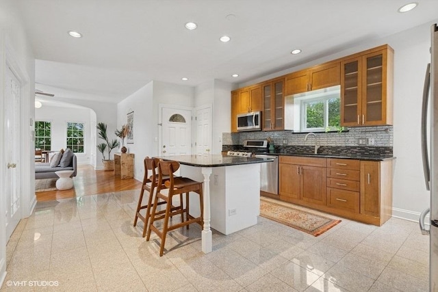 4637 N Drake Ave Unit 3, Chicago, IL 60625 - kitchen with stainless steel appliances, a breakfast bar area, brown cabinetry, healthy amount of natural light, and recessed lighting