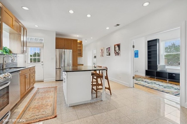 4637 N Drake Ave Unit 3, Chicago, IL 60625 - kitchen featuring stainless steel appliances, healthy amount of natural light, recessed lighting, a breakfast bar area, and a center island