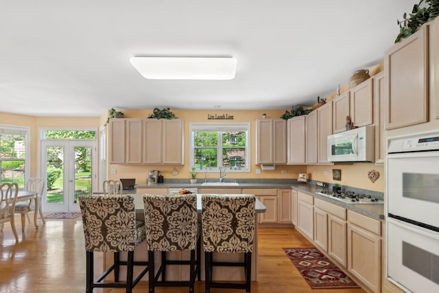 484 W Haleys Hill Ct, Palatine, IL 60074 - kitchen featuring white appliances, a kitchen breakfast bar, light wood finished floors, a kitchen island, and light brown cabinets
