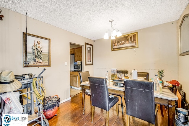 1137 Court A Dr, Hanover Park, IL 60133 - dining room with a chandelier, wood finished floors, and a textured ceiling