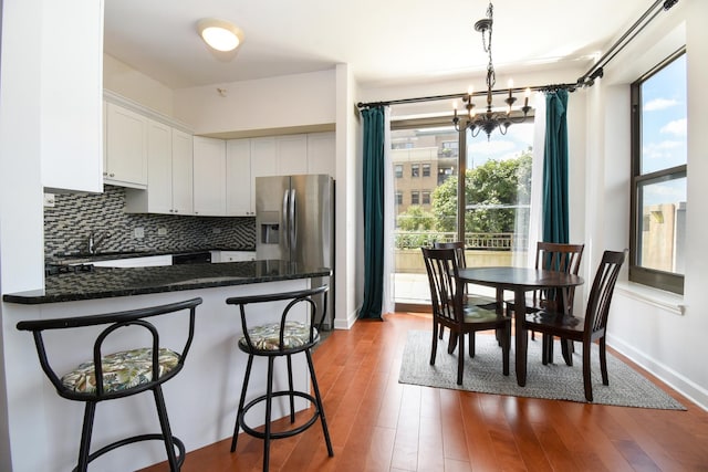 1101 S State St Unit 407, Chicago, IL 60605 - kitchen featuring white cabinets, a peninsula, a chandelier, tasteful backsplash, and stainless steel fridge with ice dispenser