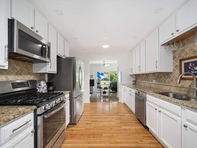 711 Bryant Ave, Barrington, IL 60010 - kitchen featuring appliances with stainless steel finishes, light wood-style floors, white cabinets, backsplash, and ceiling fan