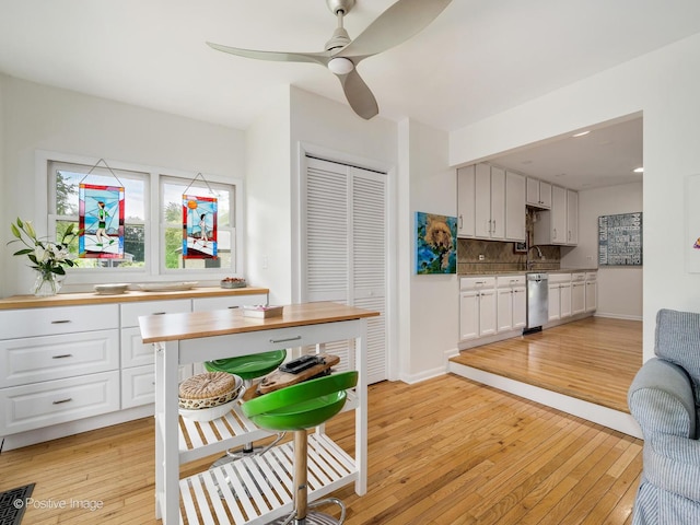 711 Bryant Ave, Barrington, IL 60010 - kitchen with dishwasher, light wood-style floors, decorative backsplash, and white cabinets