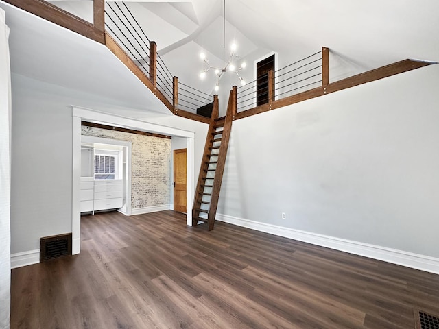 2423 Collins St, Blue Island, IL 60406 - unfurnished living room featuring a chandelier, stairway, dark wood-style floors, and a towering ceiling