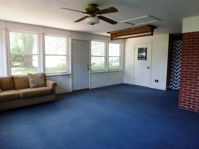503 S Wilson St, Clinton, IL 61727 - living area with dark colored carpet, ceiling fan, attic access, and brick wall
