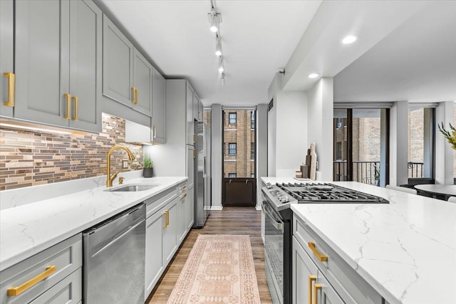 1230 N State Pkwy Unit 7D, Chicago, IL 60610 - kitchen with stainless steel appliances, backsplash, light wood-style flooring, light stone countertops, and gray cabinetry