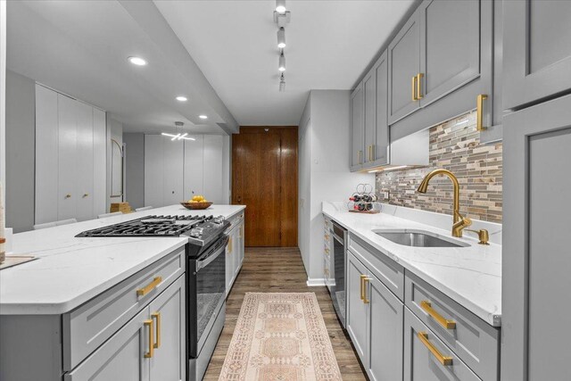 1230 N State Pkwy Unit 7D, Chicago, IL 60610 - kitchen featuring gas range, gray cabinetry, wood finished floors, decorative backsplash, and light stone counters
