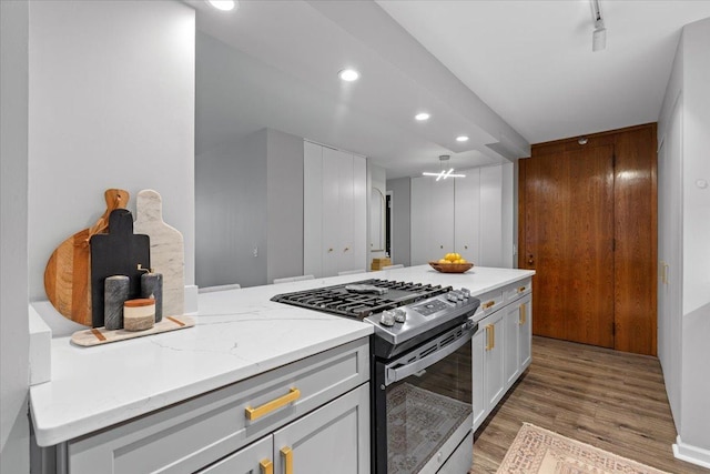 1230 N State Pkwy Unit 7D, Chicago, IL 60610 - kitchen featuring gas range, light wood-style flooring, recessed lighting, light stone counters, and white cabinets