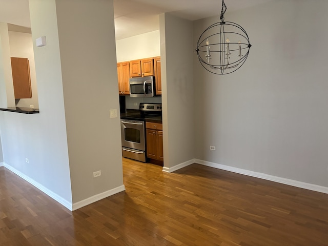 512 Pineridge Dr N Unit 512, Oswego, IL 60503 - kitchen with appliances with stainless steel finishes, dark wood-style floors, a chandelier, and dark countertops