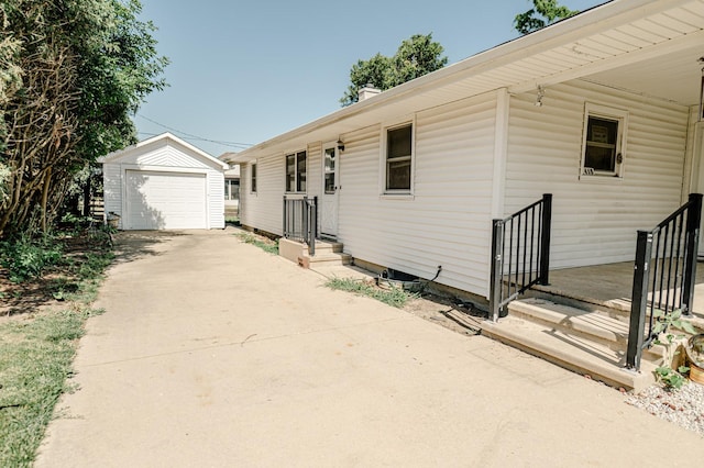 415 Swift Ave, Oglesby, IL 61348 - view of front facade with an outdoor structure, driveway, a detached garage, and a chimney