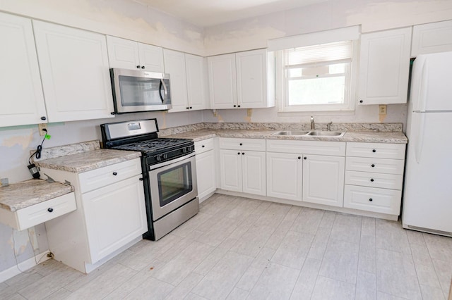 415 Swift Ave, Oglesby, IL 61348 - kitchen with appliances with stainless steel finishes, light countertops, and white cabinetry