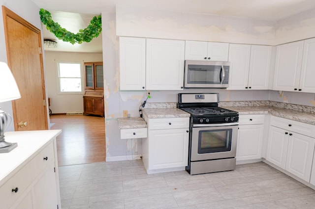 415 Swift Ave, Oglesby, IL 61348 - kitchen with appliances with stainless steel finishes, light countertops, and white cabinets