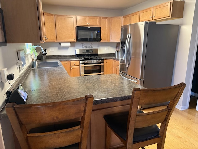 6 Kimberly Dr, Spring Valley, IL 61362 - kitchen featuring appliances with stainless steel finishes, dark countertops, a peninsula, and light wood-style flooring